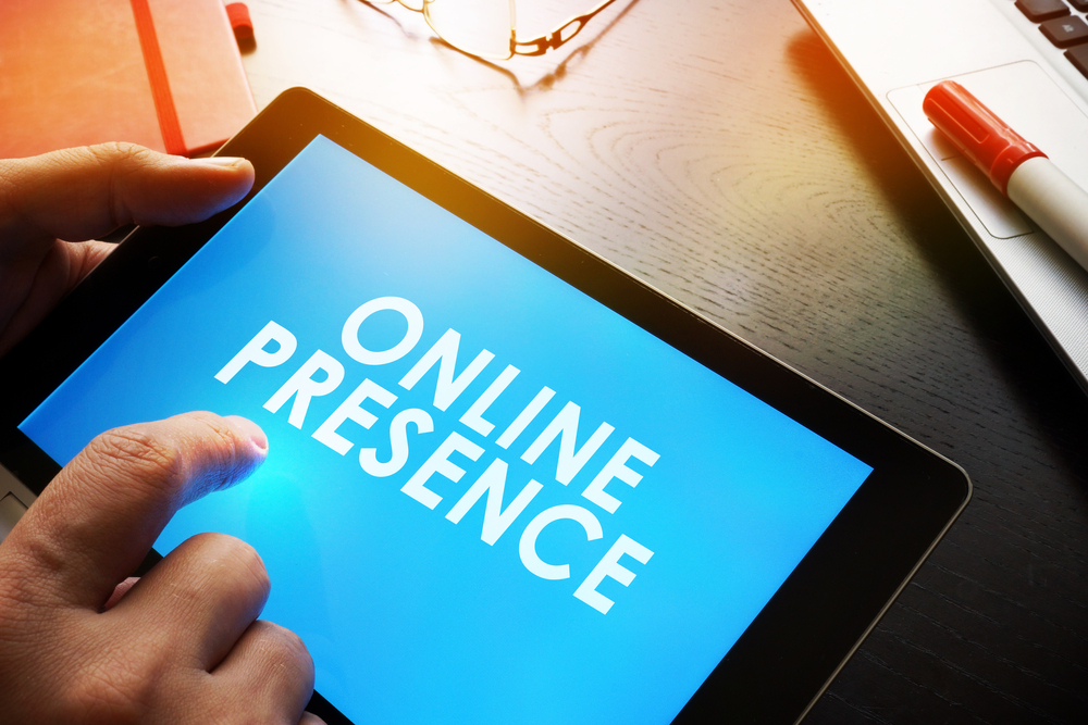 A hand holding a tablet with online presence screen on a desk.•	A hand holding a tablet with online presence screen on a desk- start affiliate marketing